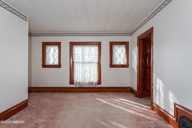 empty room featuring ornamental molding and carpet floors