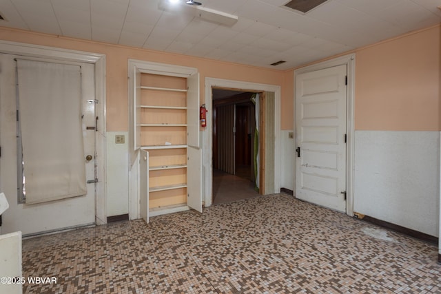 unfurnished room featuring built in shelves