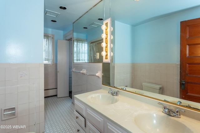 bathroom featuring tile patterned floors, toilet, tile walls, a baseboard radiator, and vanity