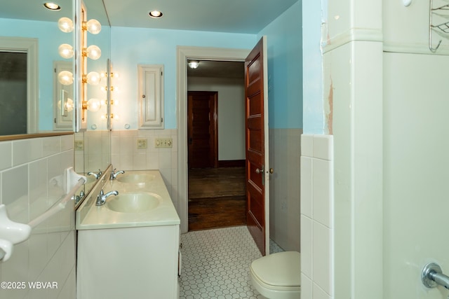 bathroom with tile walls, vanity, and toilet