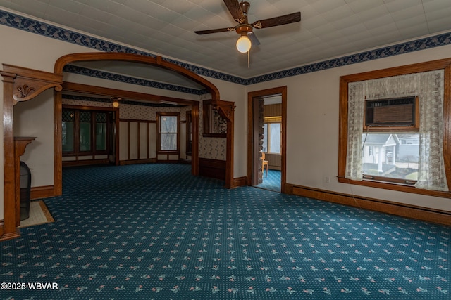 empty room featuring ornamental molding, carpet floors, a wall unit AC, and ceiling fan