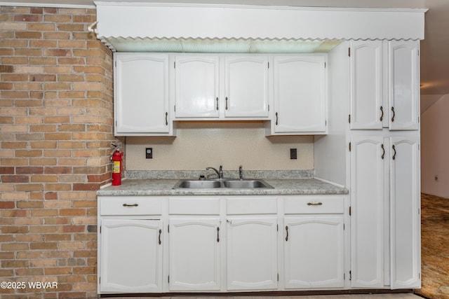 kitchen featuring white cabinetry and sink