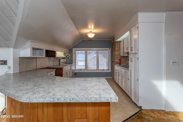 kitchen featuring vaulted ceiling and kitchen peninsula