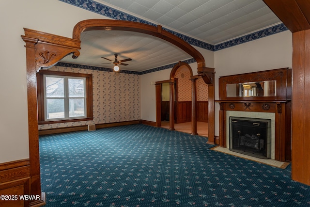 interior space featuring a fireplace, carpet floors, and ceiling fan