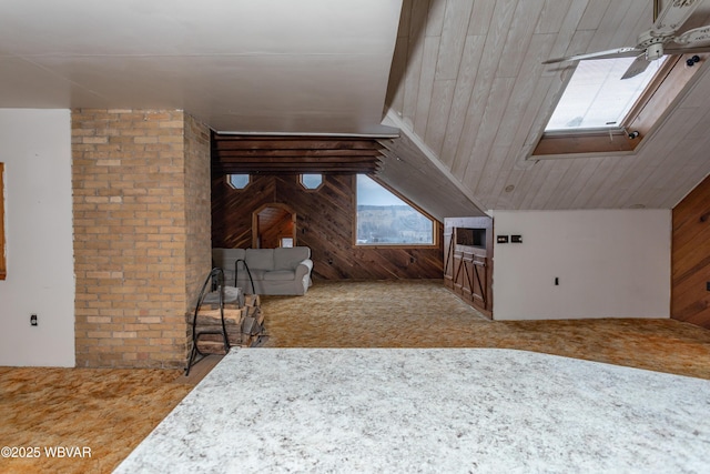 additional living space with ceiling fan, lofted ceiling, carpet floors, and wooden walls