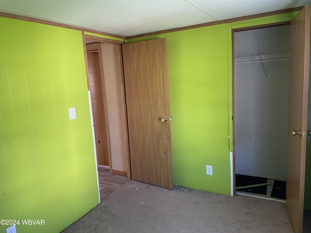 unfurnished bedroom with a closet, carpet, and a textured ceiling