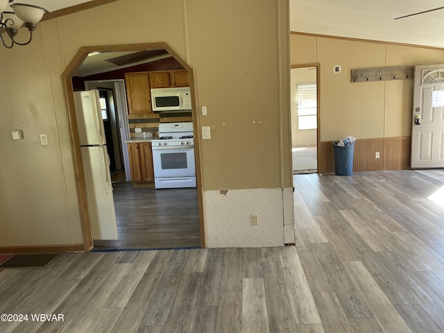 kitchen with hardwood / wood-style flooring, white appliances, and vaulted ceiling