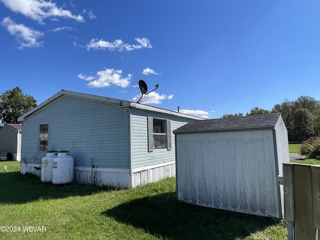 view of home's exterior with a yard and a storage shed