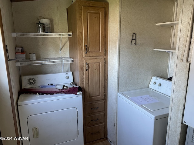 clothes washing area featuring cabinets and independent washer and dryer