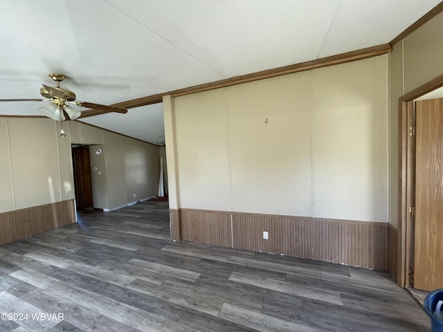 unfurnished room with ceiling fan, dark wood-type flooring, wood walls, a textured ceiling, and lofted ceiling