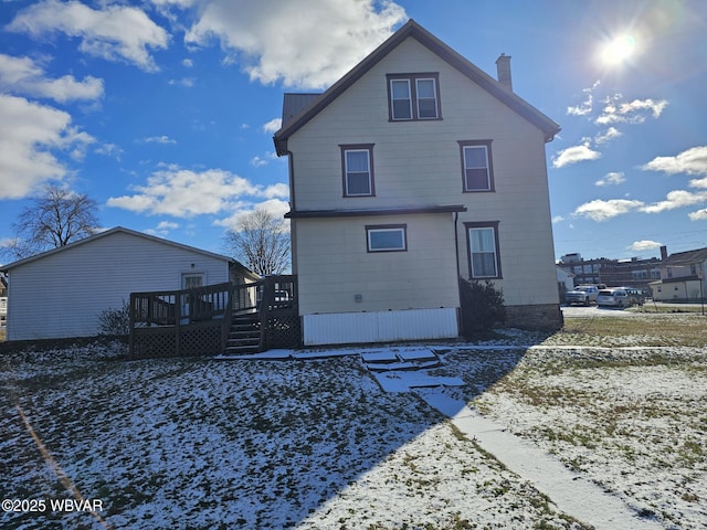 snow covered house with a deck