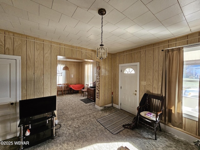 carpeted foyer with wooden walls