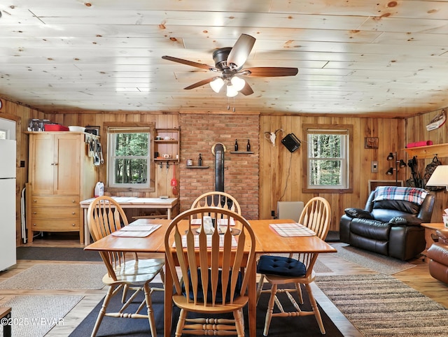 110 Worlds End Rd, Muncy Valley, PA 17758 - dining space with healthy amount of natural light, wood walls, a wood stove, a ceiling fan, and light wood-style floors