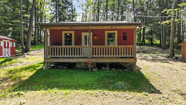 110 Worlds End Rd, Muncy Valley, PA 17758 - view of front of home with a chimney, a metal roof, an outbuilding, a front lawn, and covered porch