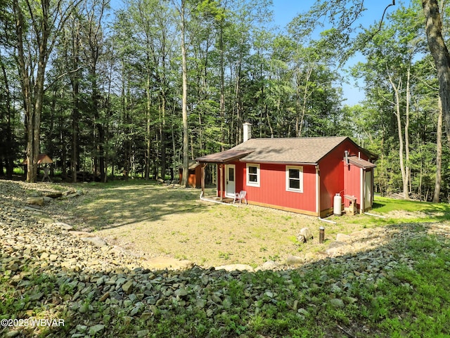 110 Worlds End Rd, Muncy Valley, PA 17758 - view of home's exterior featuring a shingled roof, an outbuilding, a lawn, a chimney, and a view of trees
