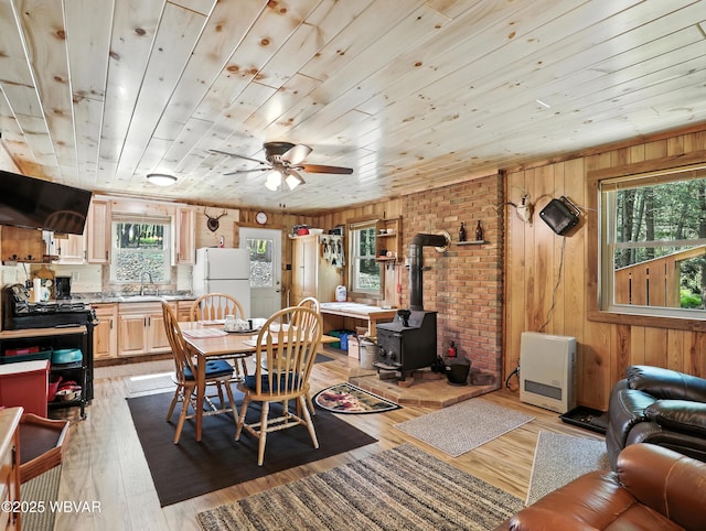110 Worlds End Rd, Muncy Valley, PA 17758 - dining space with a wood stove, ceiling fan, wood walls, light wood-style floors, and heating unit