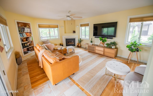 335 Chirlton Pt, Montoursville, PA 17754 - living room with ceiling fan, a glass covered fireplace, built in shelves, and light wood-type flooring
