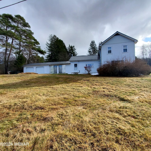 rear view of house with a garage and a lawn