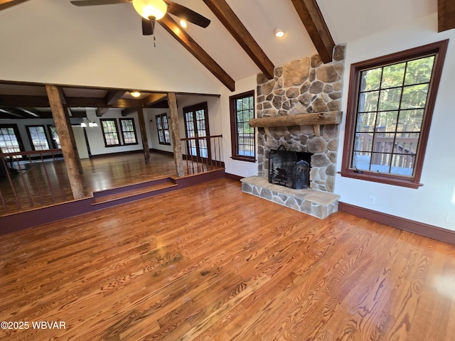 unfurnished living room featuring baseboards, beamed ceiling, a fireplace, wood finished floors, and high vaulted ceiling