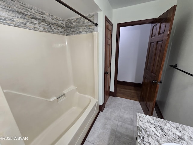 full bath featuring tile patterned flooring, tub / shower combination, and baseboards