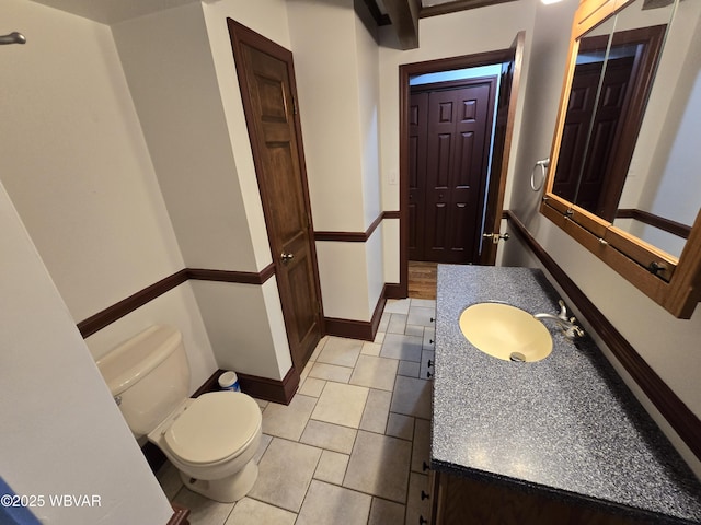 bathroom with tile patterned floors, toilet, vanity, and baseboards