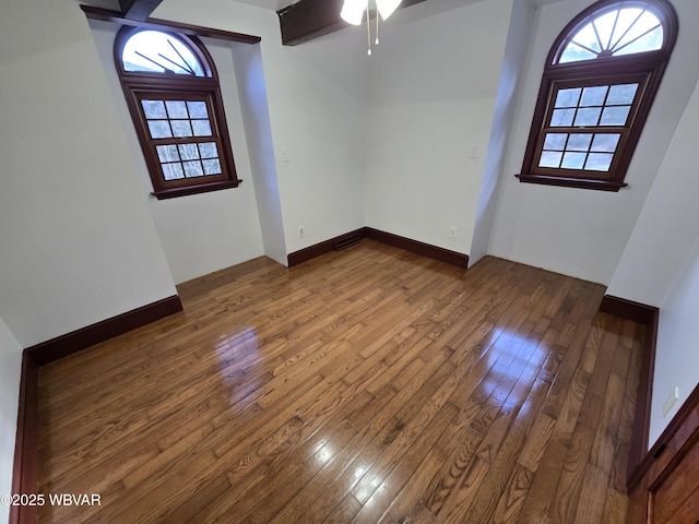 empty room featuring a ceiling fan, baseboards, and wood-type flooring