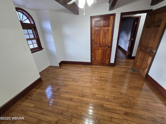 unfurnished bedroom featuring visible vents, baseboards, and hardwood / wood-style floors