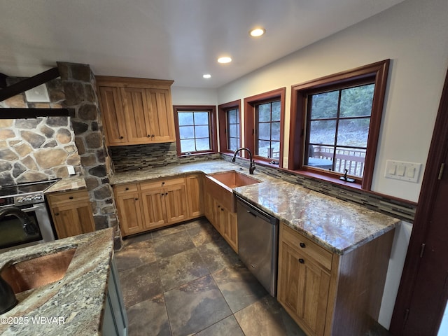 kitchen featuring wall oven, dishwasher, light stone countertops, and a sink