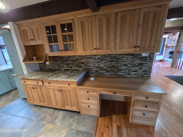 kitchen with glass insert cabinets, a healthy amount of sunlight, and backsplash