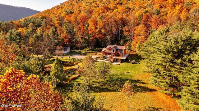 birds eye view of property with a mountain view and a wooded view