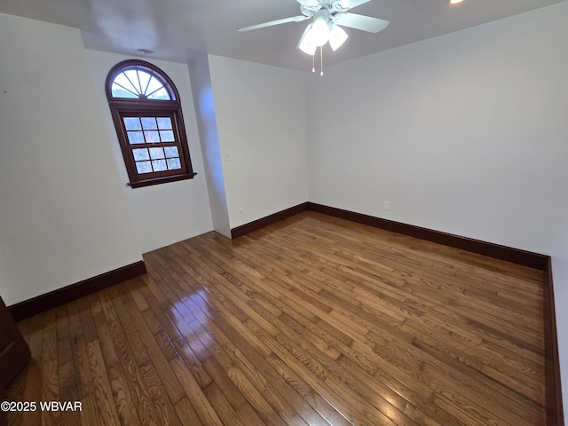 unfurnished room with ceiling fan, baseboards, and wood-type flooring