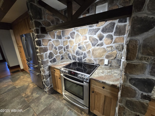 kitchen featuring light stone countertops, appliances with stainless steel finishes, and brown cabinets