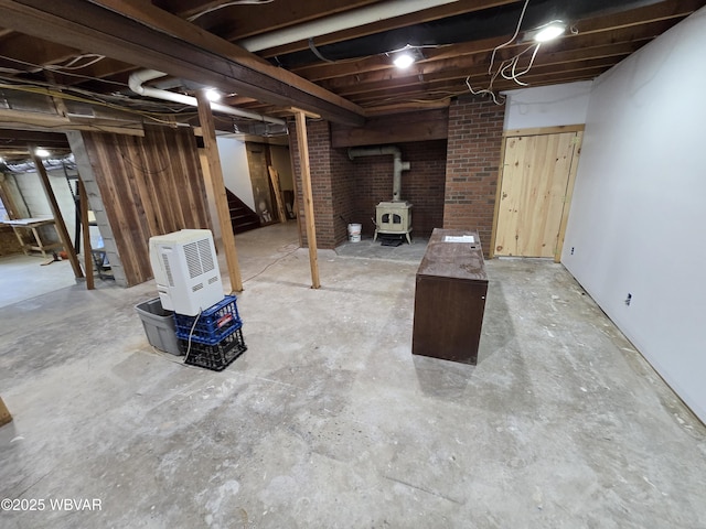 unfinished basement featuring stairway and a wood stove