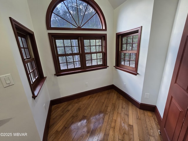 interior space with baseboards and dark wood-style flooring