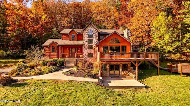 log home with a wooden deck, a lawn, french doors, a chimney, and stone siding