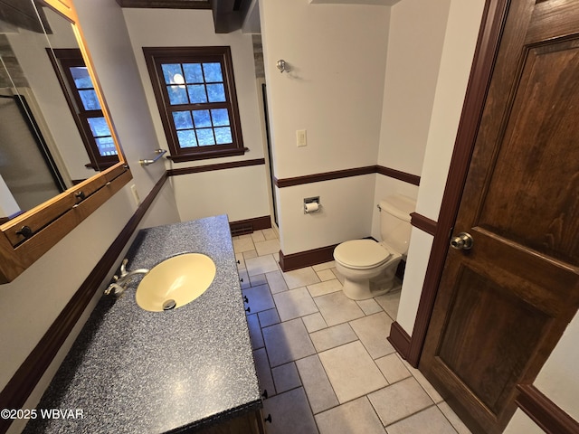 bathroom with vanity, toilet, and baseboards