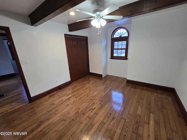 empty room with visible vents, baseboards, beamed ceiling, a ceiling fan, and wood-type flooring