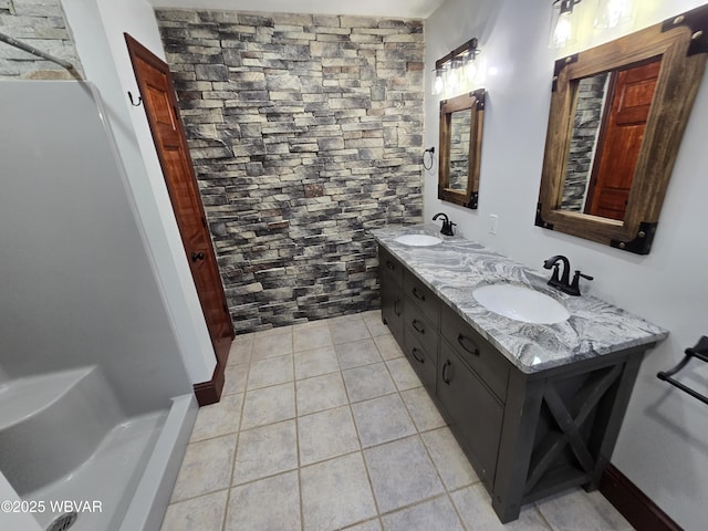 full bathroom featuring tile patterned floors, double vanity, and a sink