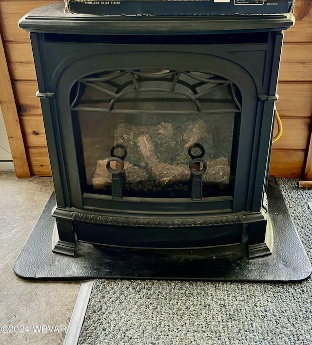 room details featuring a wood stove and wooden walls