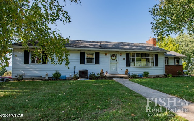 single story home featuring central AC unit and a front lawn