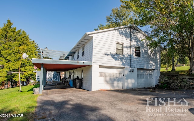 view of side of home with a garage and a carport