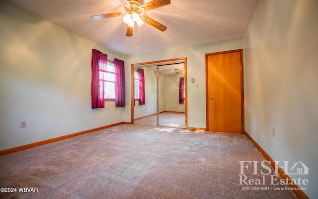 unfurnished bedroom featuring ceiling fan, light carpet, and a closet