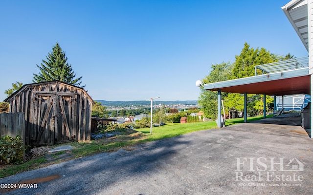 view of parking / parking lot featuring a mountain view and a yard