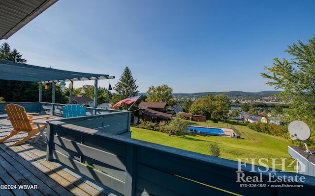 deck featuring a lawn, a pergola, and a mountain view