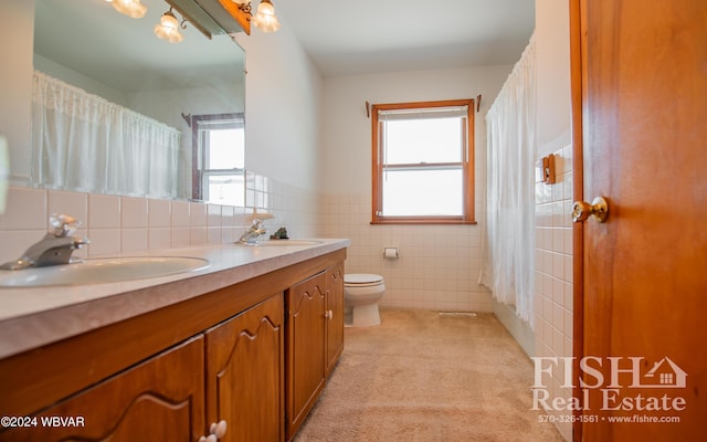 bathroom featuring a wealth of natural light, vanity, tile walls, and toilet