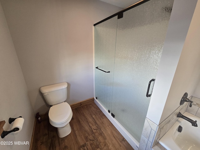 bathroom featuring hardwood / wood-style floors, toilet, and a shower with shower door