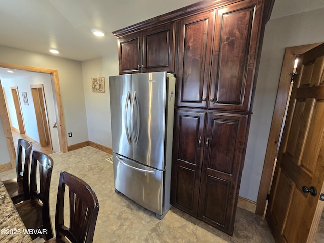 kitchen with stainless steel fridge and light stone countertops