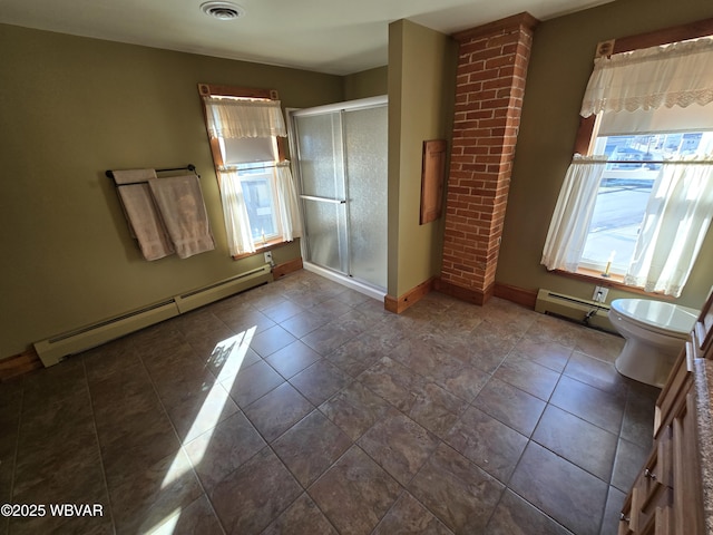 tiled spare room featuring a baseboard heating unit