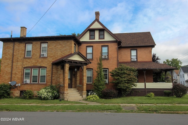 view of front of home with cooling unit and a front lawn