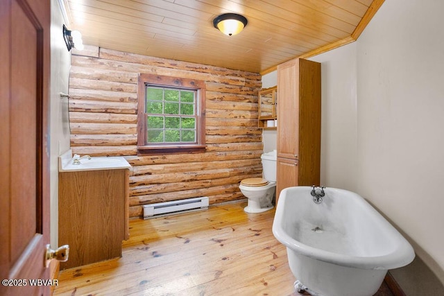 175 Hemlock Ln, Millville, PA 17846 - bathroom featuring log walls, a baseboard radiator, wood ceiling, a freestanding tub, and toilet